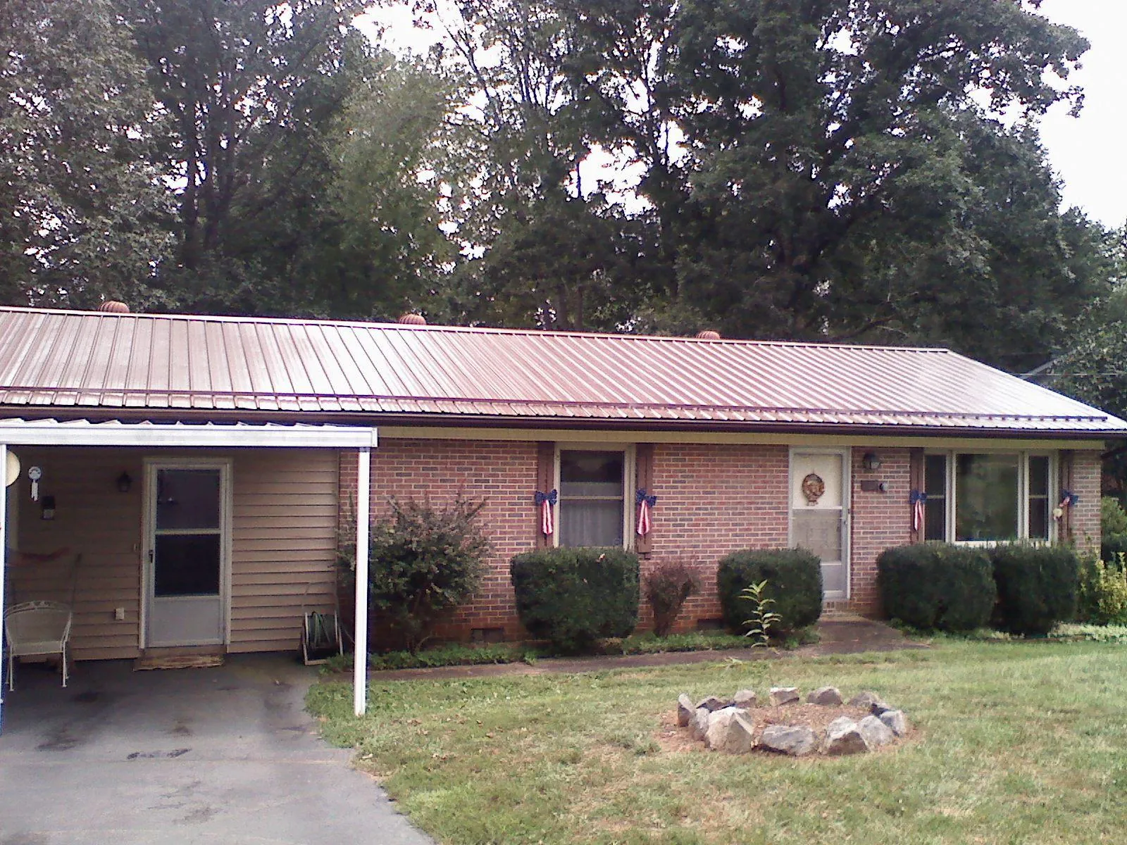 Bronze metal roof and carport on a brick ranch home — Roof Repair work by our crew in Durant