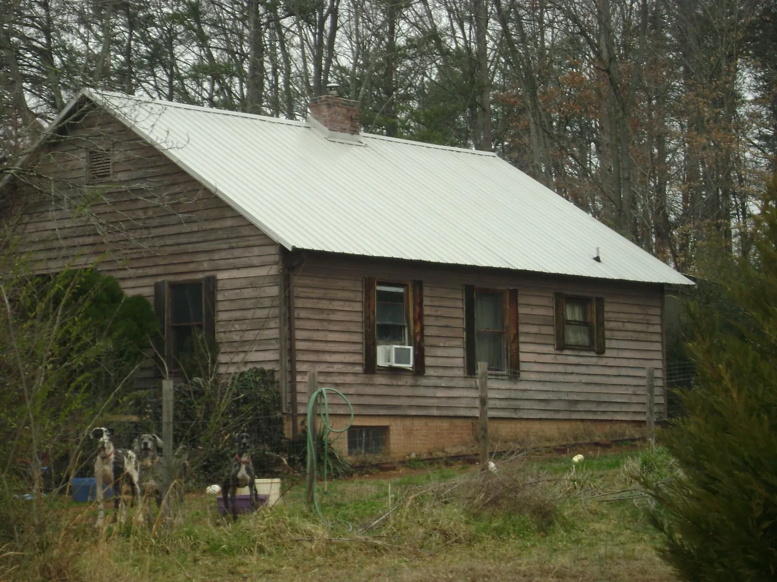 White metal roof on an old wood sided farmhouse, from a Metal Roof Installation job in Durant